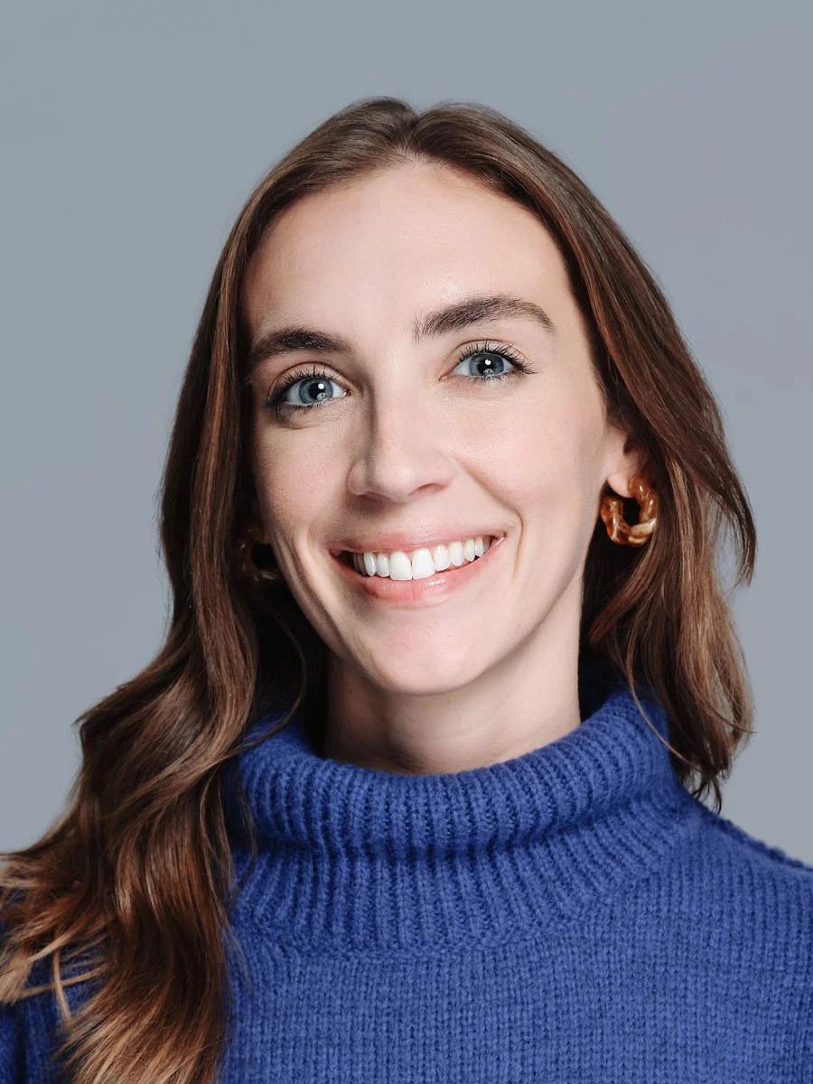 corporate-headshot-nyc-woman-blue-sweater-gray-background.jpg