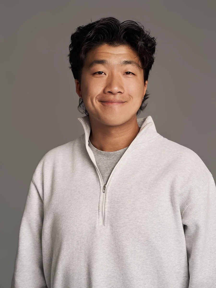 studio-headshot-nyc-man-gray-sweater-green-background.jpg
