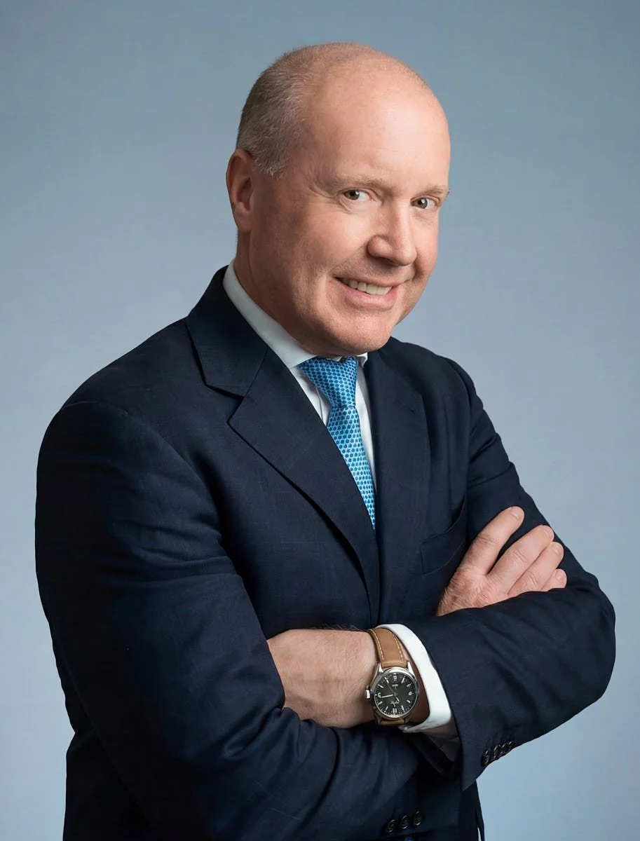Remote team portrait with folded arms against a blue-gray background.