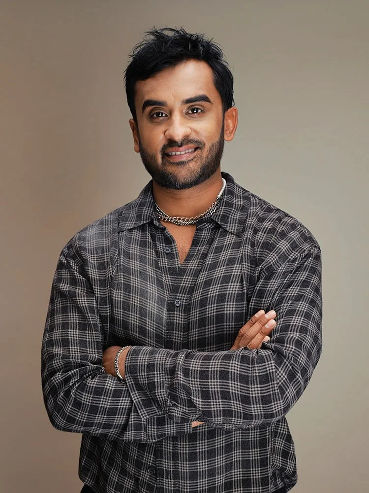 Person in a plaid shirt standing with one hand at the waist.