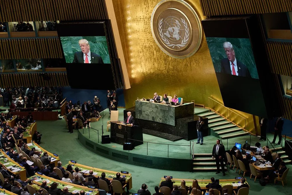Wide view of a speaker and audience in a large auditorium.