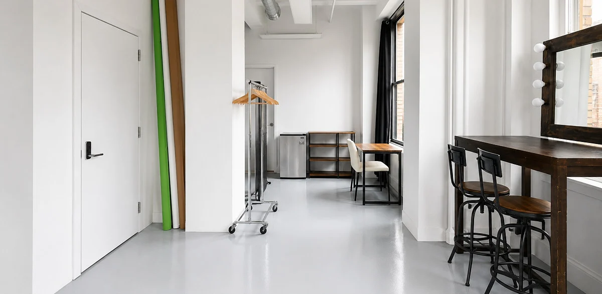 Open shooting floor in our Midtown studio with windows, white walls, and studio stands.