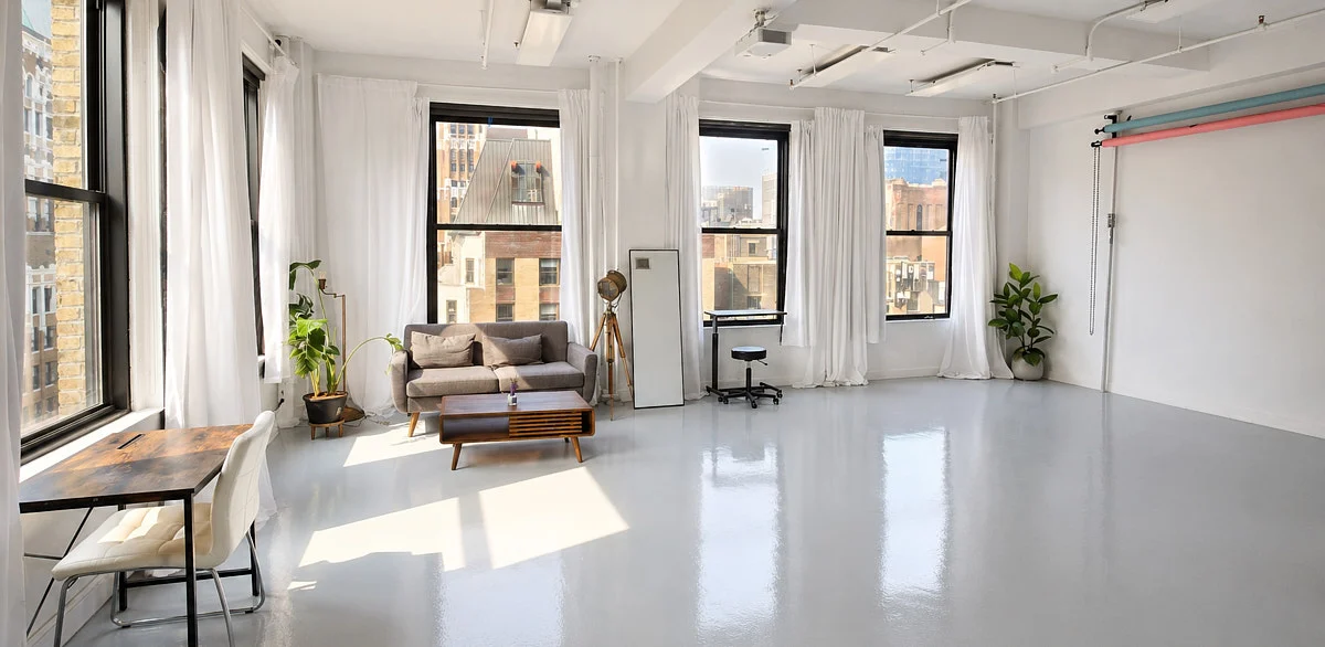 Midtown photography studio with tall windows, an open shooting floor, and lounge seating.