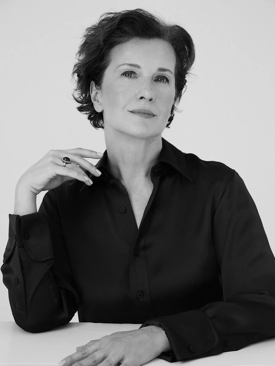 Black-and-white seated portrait of a woman in a dark blouse.