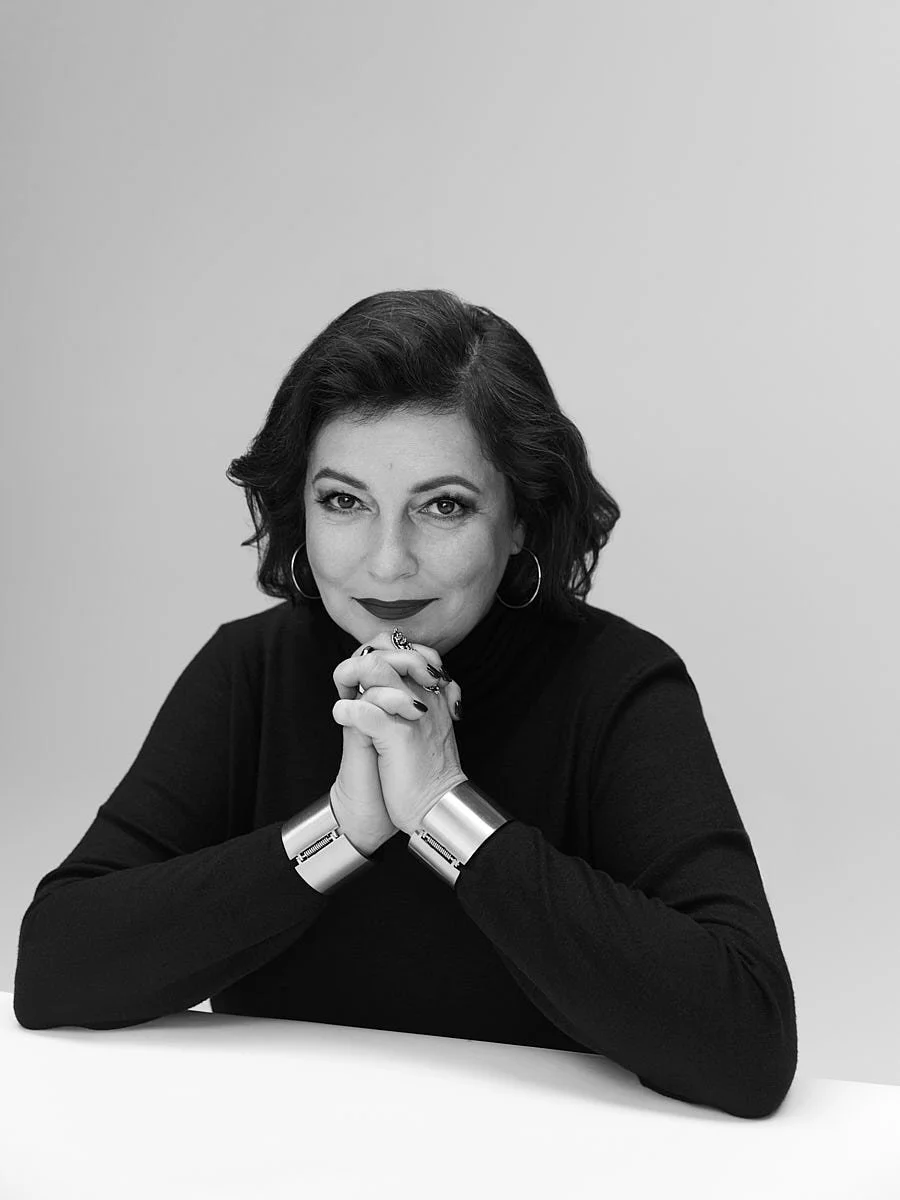 Black-and-white portrait of a woman resting her chin on her hands.