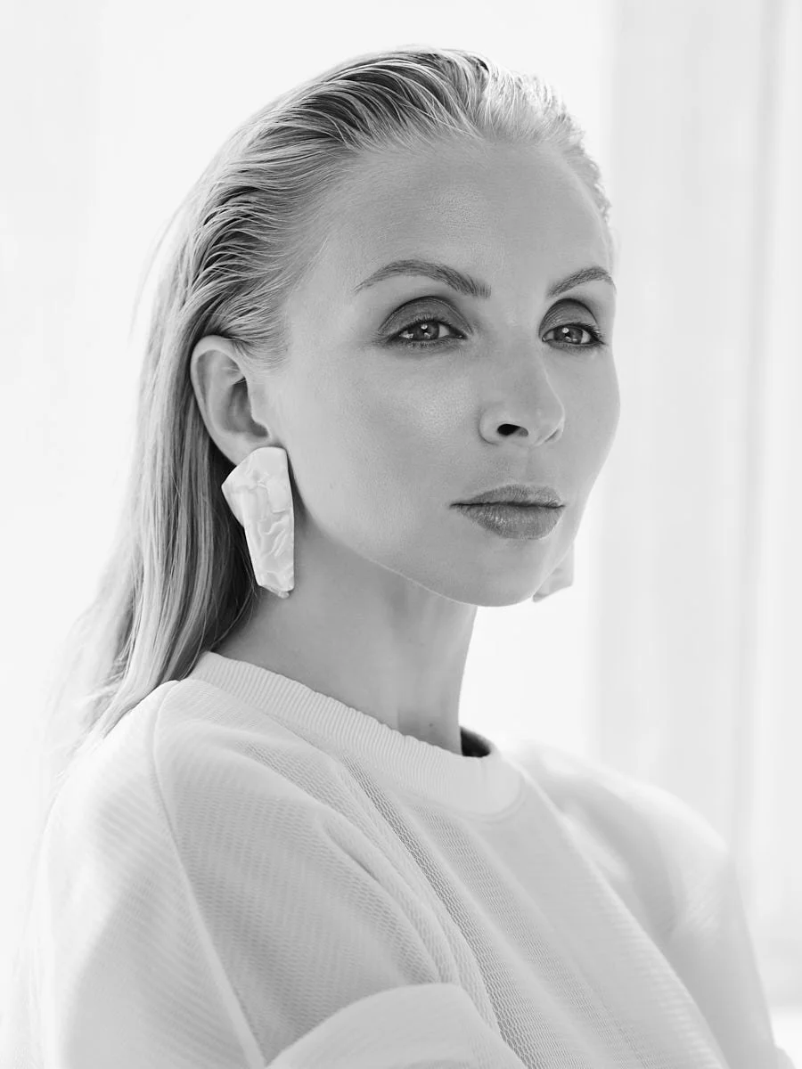 Black-and-white close portrait of a woman in a white top.