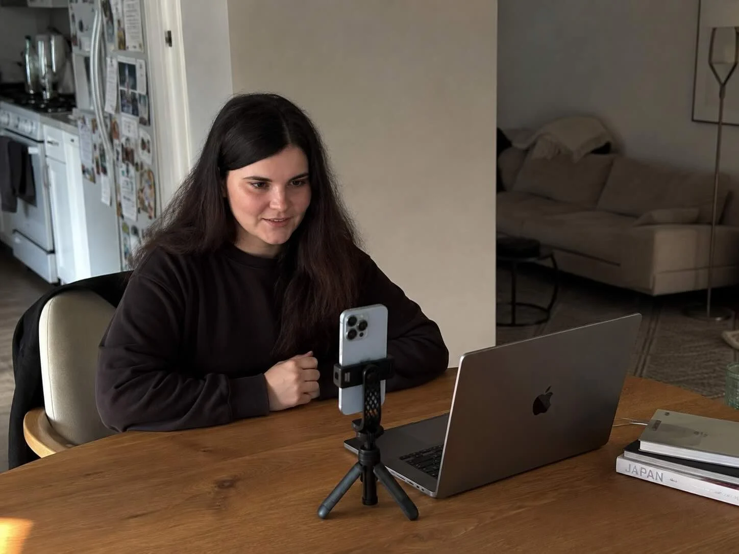Laptop on a desk displays a remote portrait session in a home workspace.