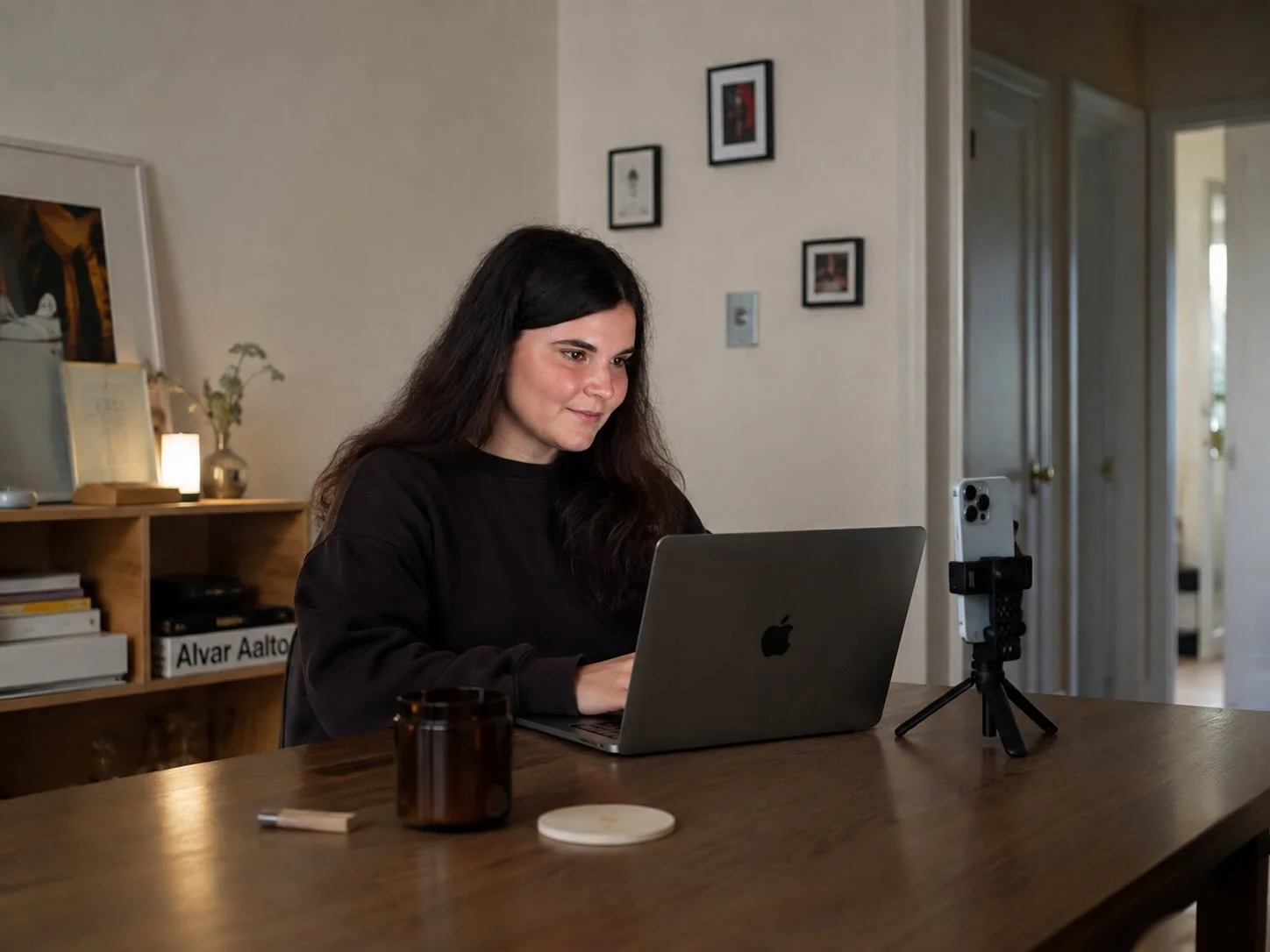 A person sits at a desk with a laptop during a remote portrait session.